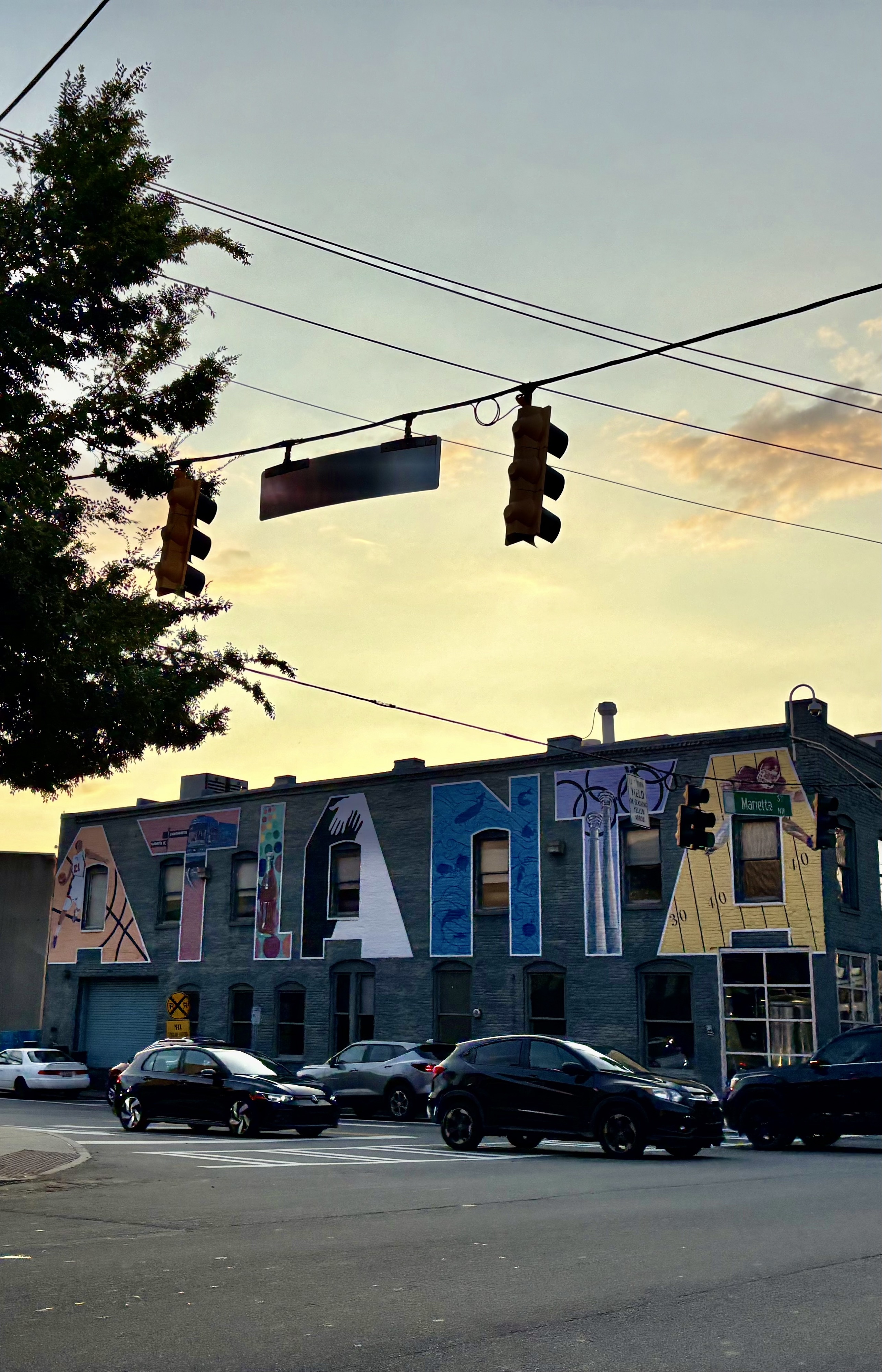 Building at dusk with ‘ATLANTA’ on the side. Cars in front. Sun fading. Atlanta, GA